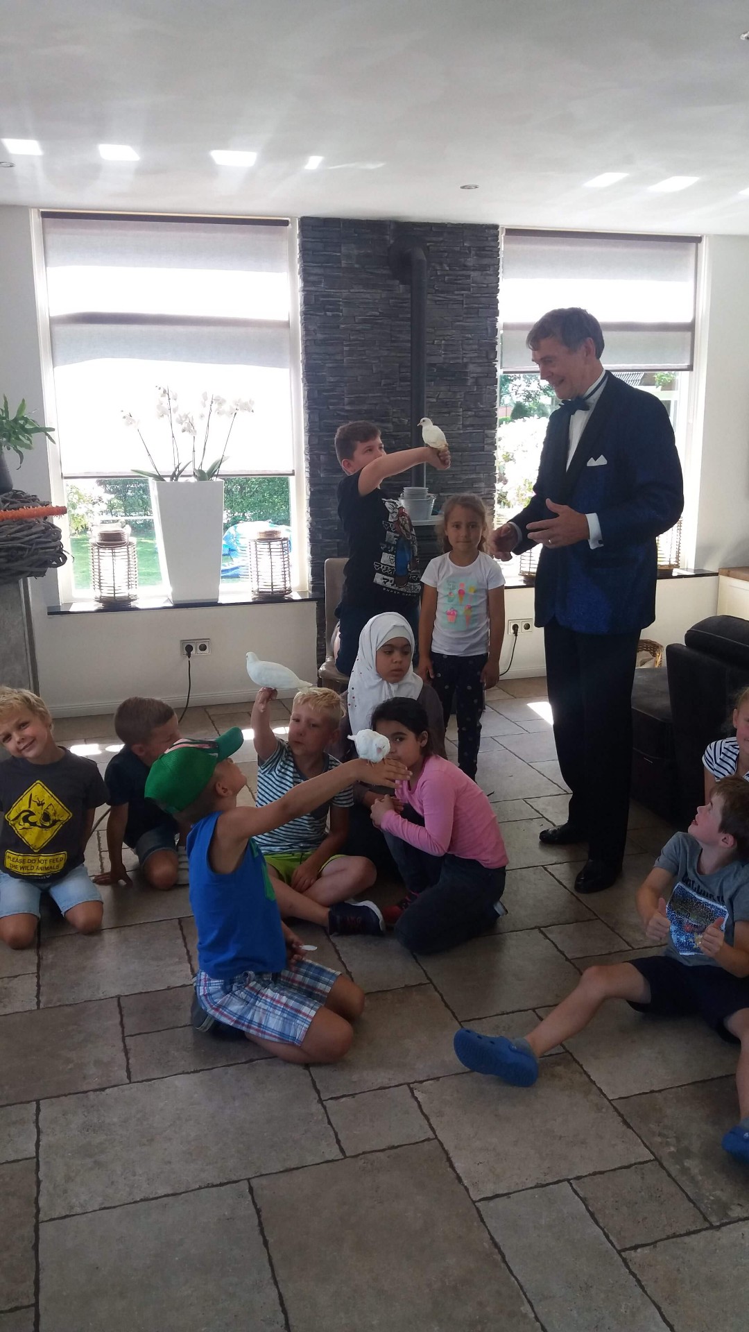 Kinderen lachen om een truc van de goochelaar op een kinderfeestje